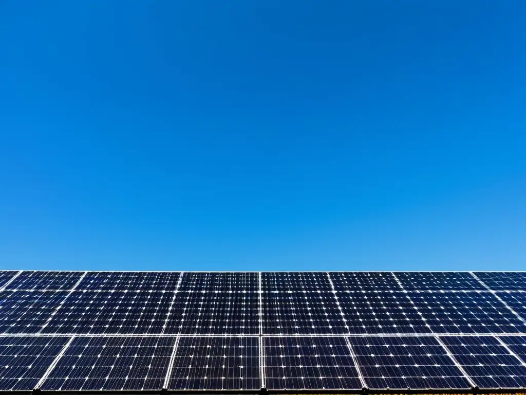 Gestión proyectos energía solar comunitaria: Paneles solares modernos en un cielo azul, transmitiendo eficiencia y energía renovable comunitaria